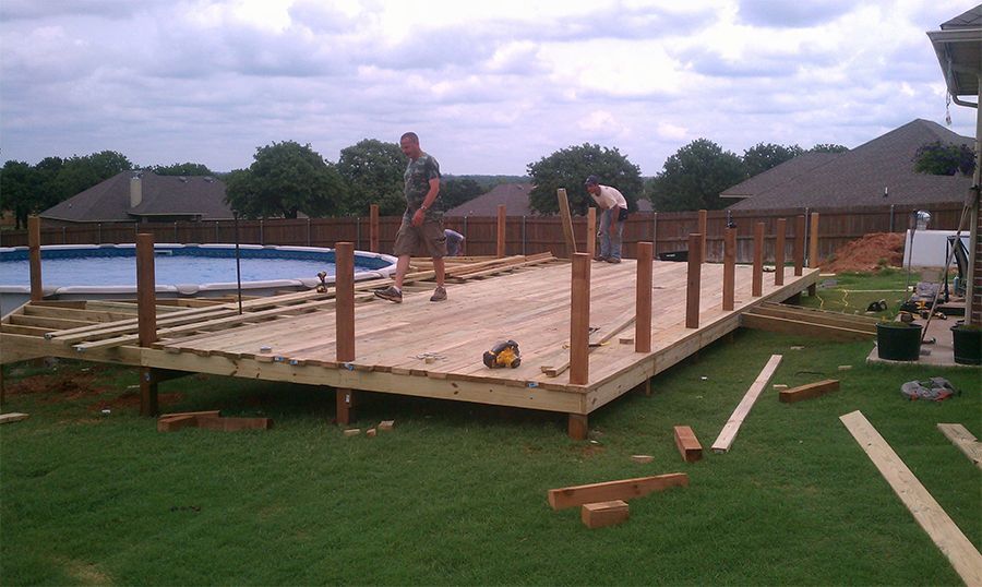 A wooden deck is being built next to a pool