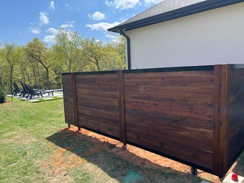 A wooden fence is sitting in front of a house.