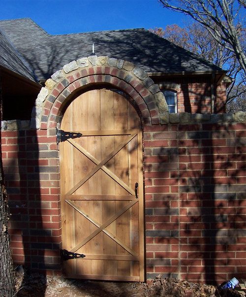 A wooden door is built into a brick wall