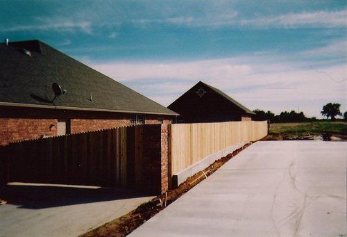 A brick house with a wooden fence in front of it