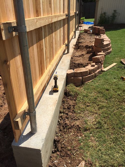 A wooden fence is being built in a backyard.