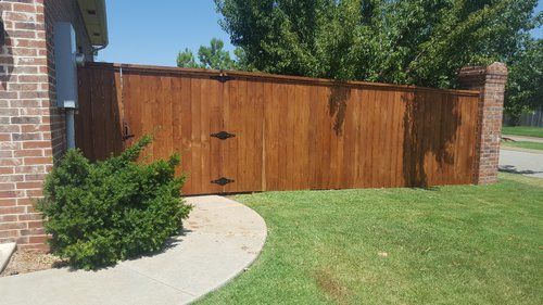 A wooden fence is sitting in front of a brick building.