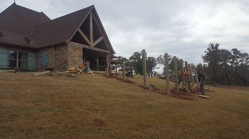 A large house is being built in the middle of a grassy field.