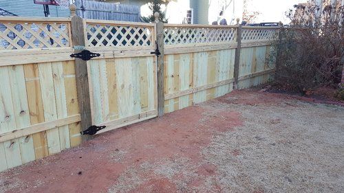 A wooden fence with a gate in the backyard.