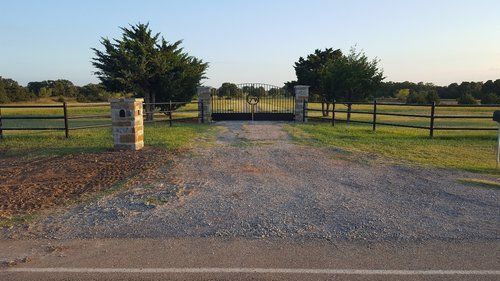 A dirt road with a gate in the middle of it