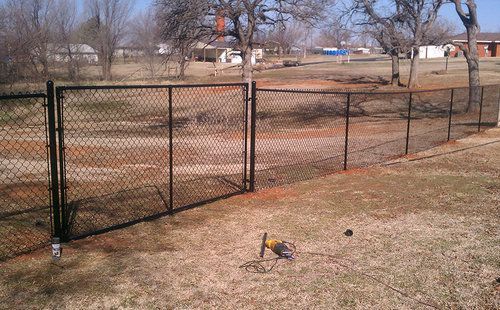A chain link fence is being built in a yard.