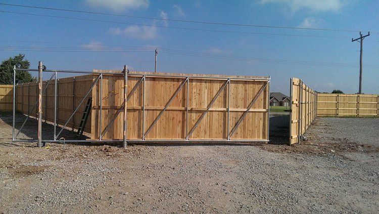 A wooden fence is being built in a gravel area