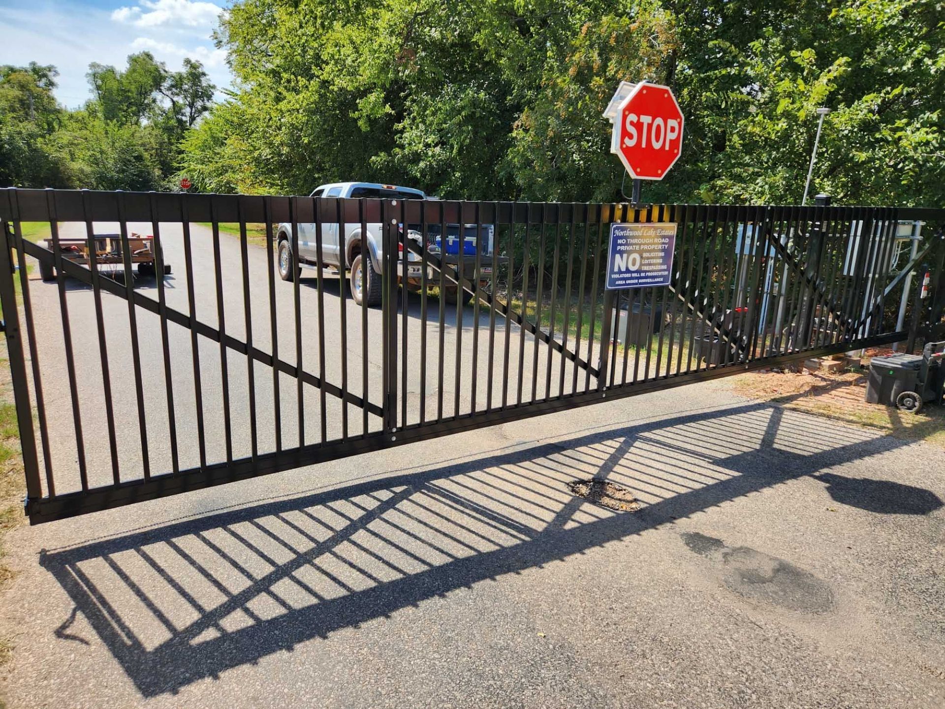 A stop sign is hanging from a metal gate.