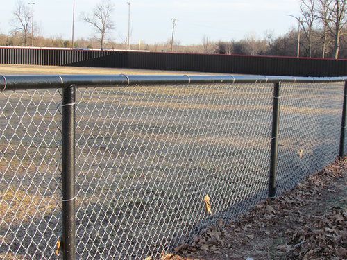 A chain link fence surrounds a baseball field.