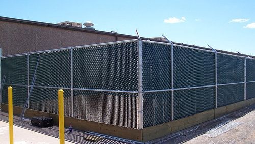 A chain link fence is surrounding a large building
