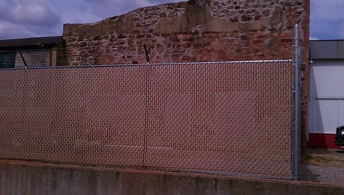A chain link fence is surrounding a brick building.