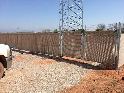 A truck is parked in front of a chain link fence.
