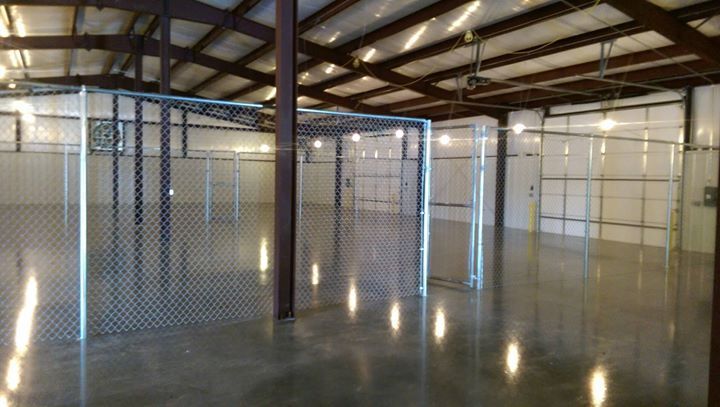 A large empty warehouse with a chain link fence in the middle.