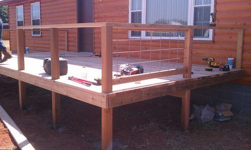A wooden deck is being built in front of a house
