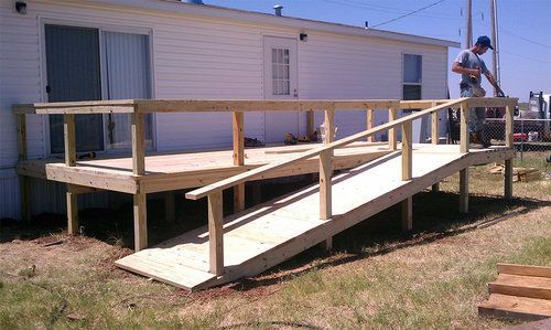 A wooden ramp is being built in front of a mobile home