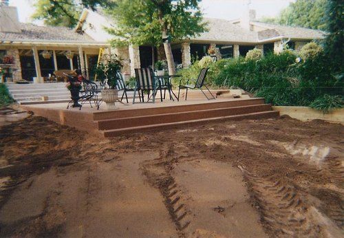 A patio with a table and chairs in front of a house