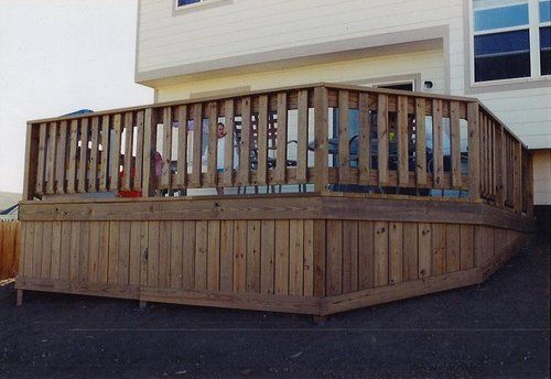 A large wooden deck is in front of a house