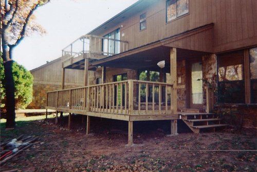 A large wooden deck is sitting in front of a house