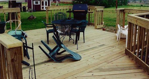 A wooden deck with a table and chairs on it