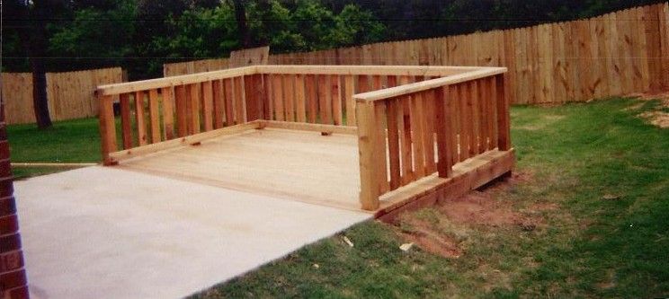 A wooden deck with a wooden fence in the backyard.