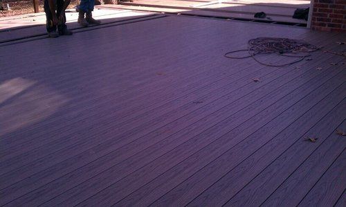 A person is standing on a purple wooden deck.