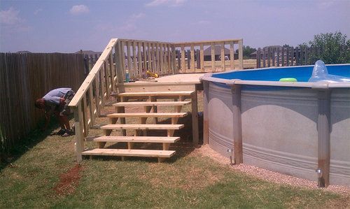 A man is working on a deck next to a pool