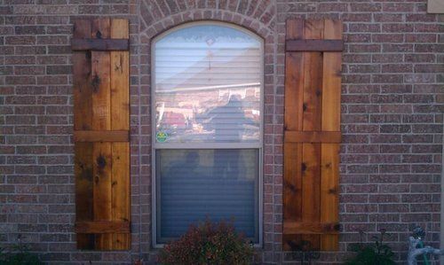 A brick building with wooden shutters on the windows.