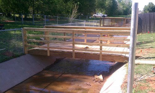 A wooden bridge is being built over a stream