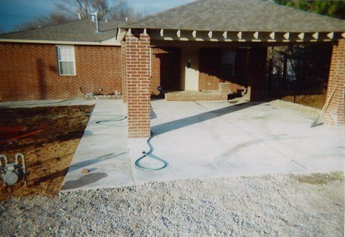 A brick house with a concrete walkway leading to it