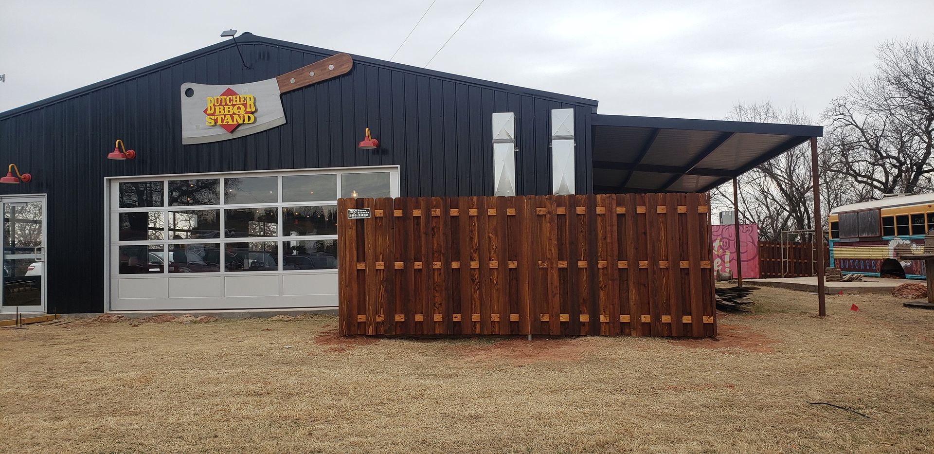 A large black building with a wooden fence in front of it.