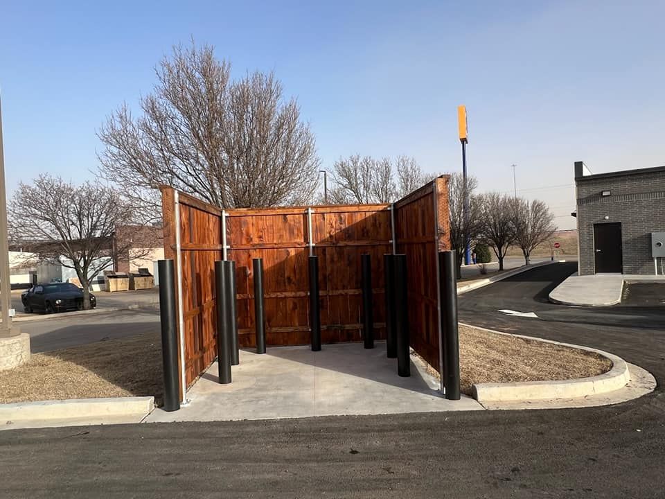 A wooden fence is in the middle of a parking lot