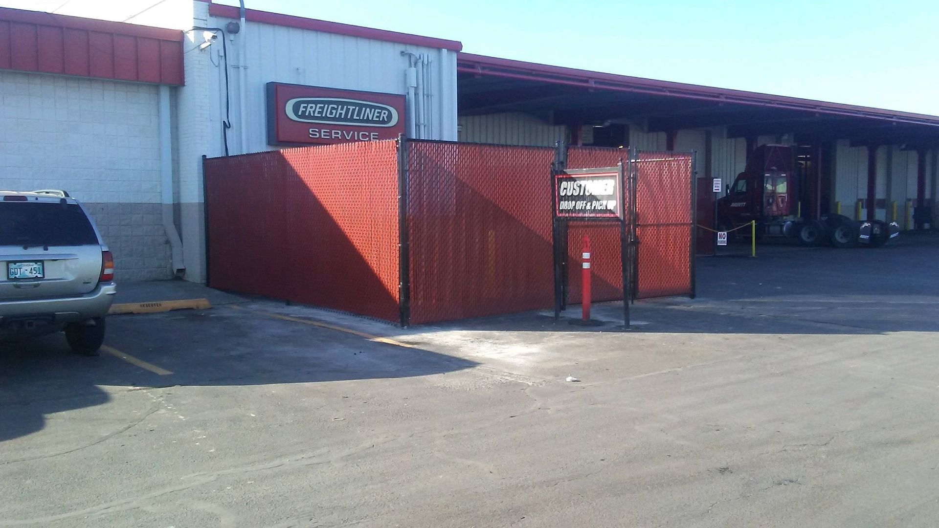 A car is parked in front of a building that says freightliner