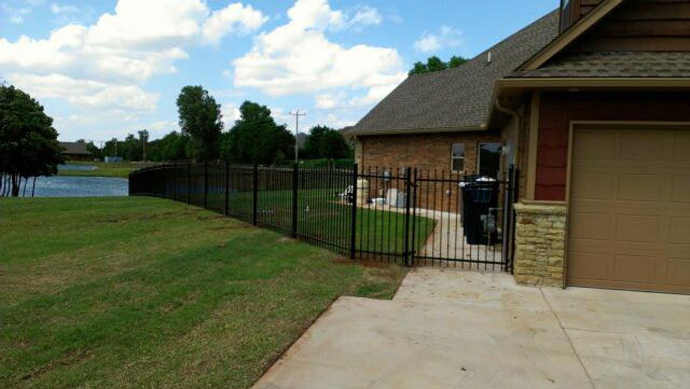A house with a fence around it and a driveway leading to it