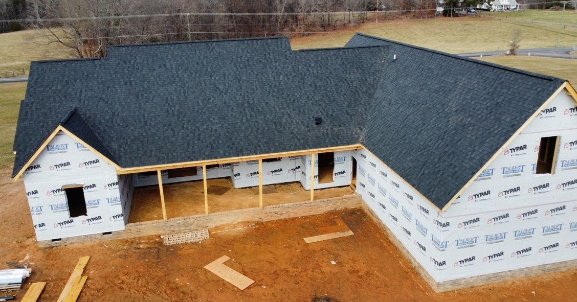 an aerial view of a house under construction with a black roof .
