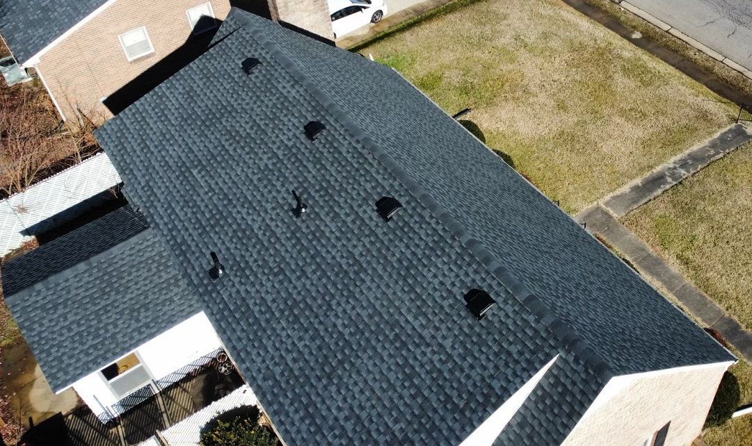 an aerial view of a house with a black roof .