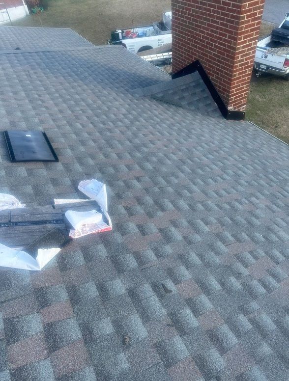 a roof with a brick chimney and a lot of shingles on it .