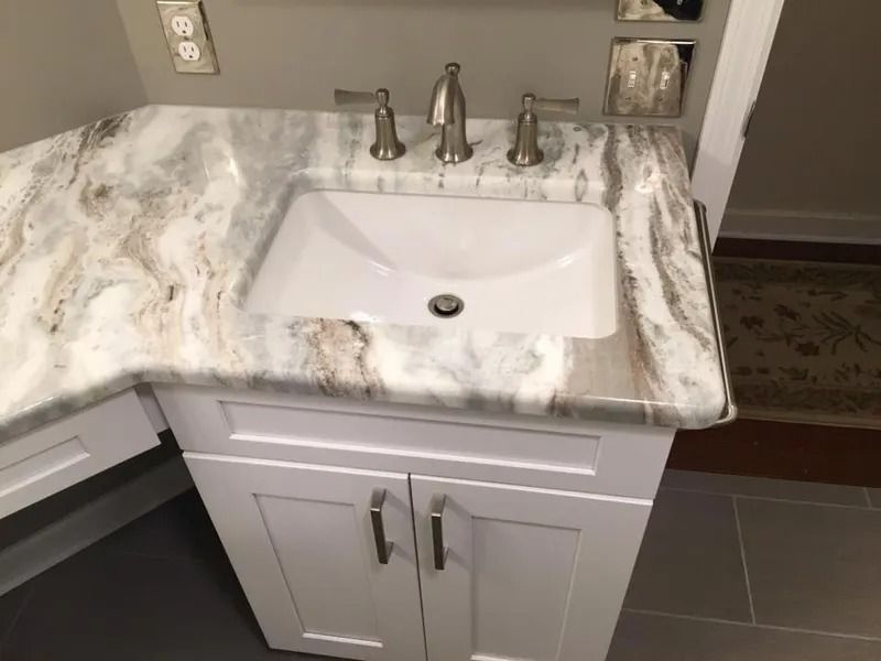 White vanity with a marble countertop and a rectangular sink.