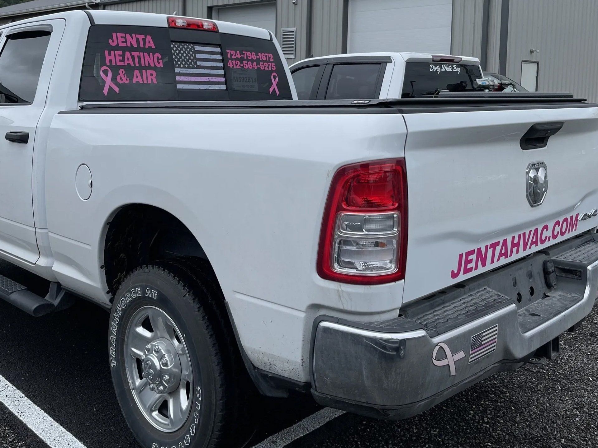 White pick up truck with pink logo