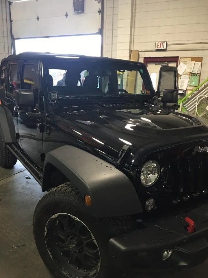 Black Jeep truck inside a warehouse garage