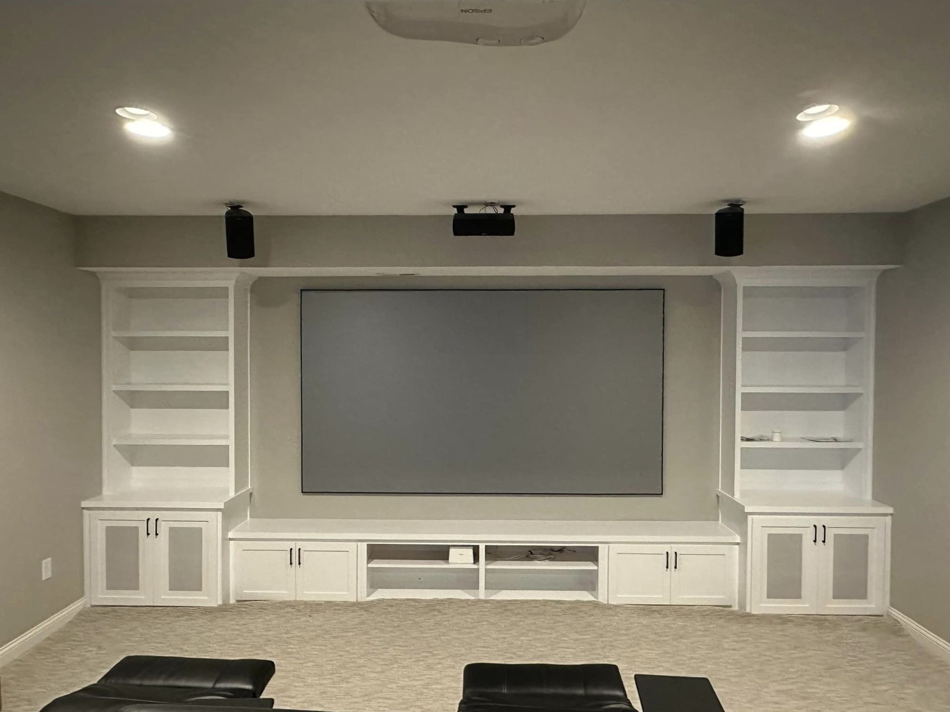 A home theater with a large screen and shelves
