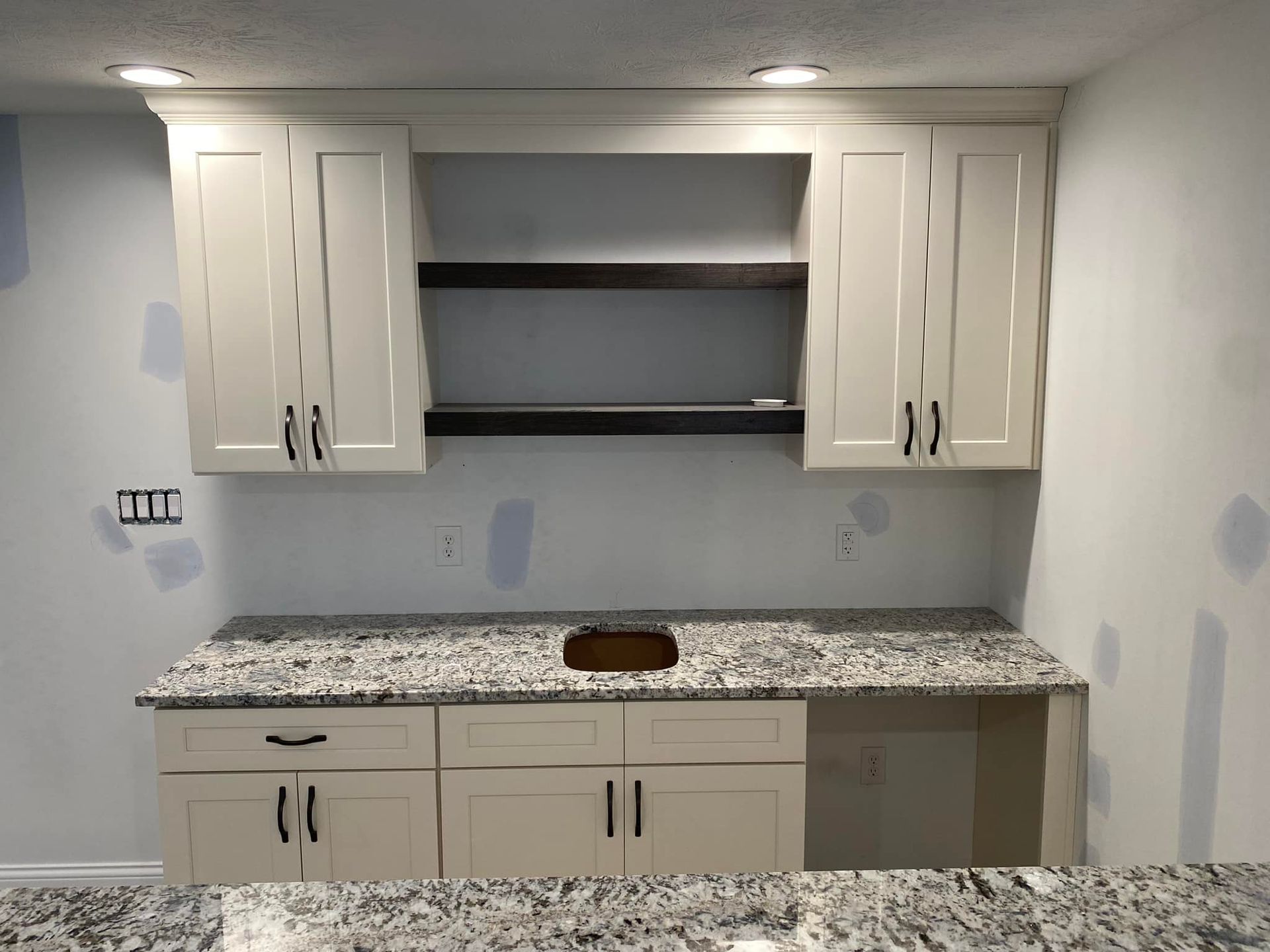 A kitchen with white cabinets and granite counter tops