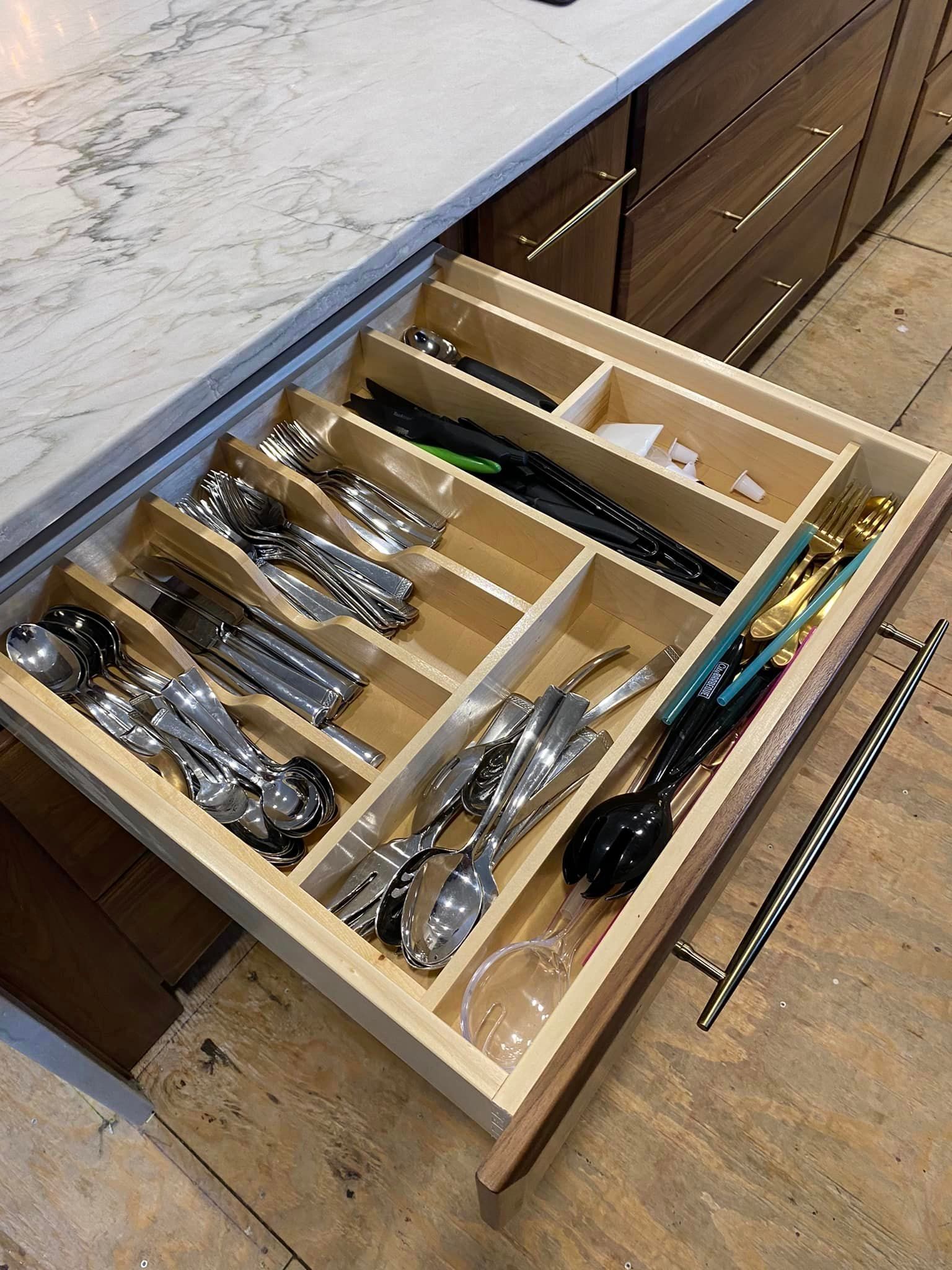 A kitchen drawer filled with silverware and utensils.