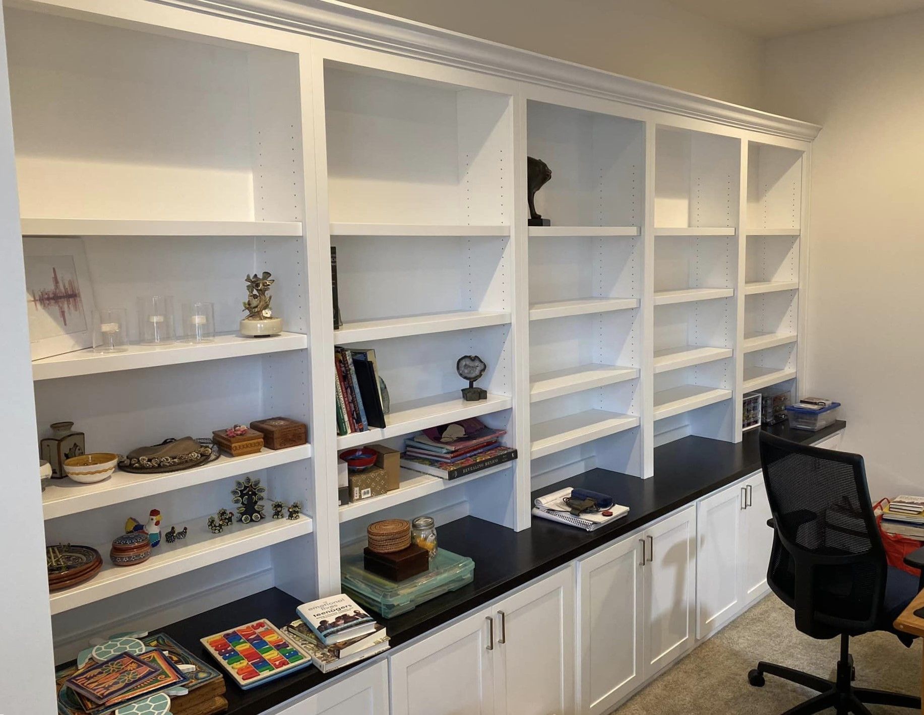 A room with a lot of shelves and a desk with a chair.