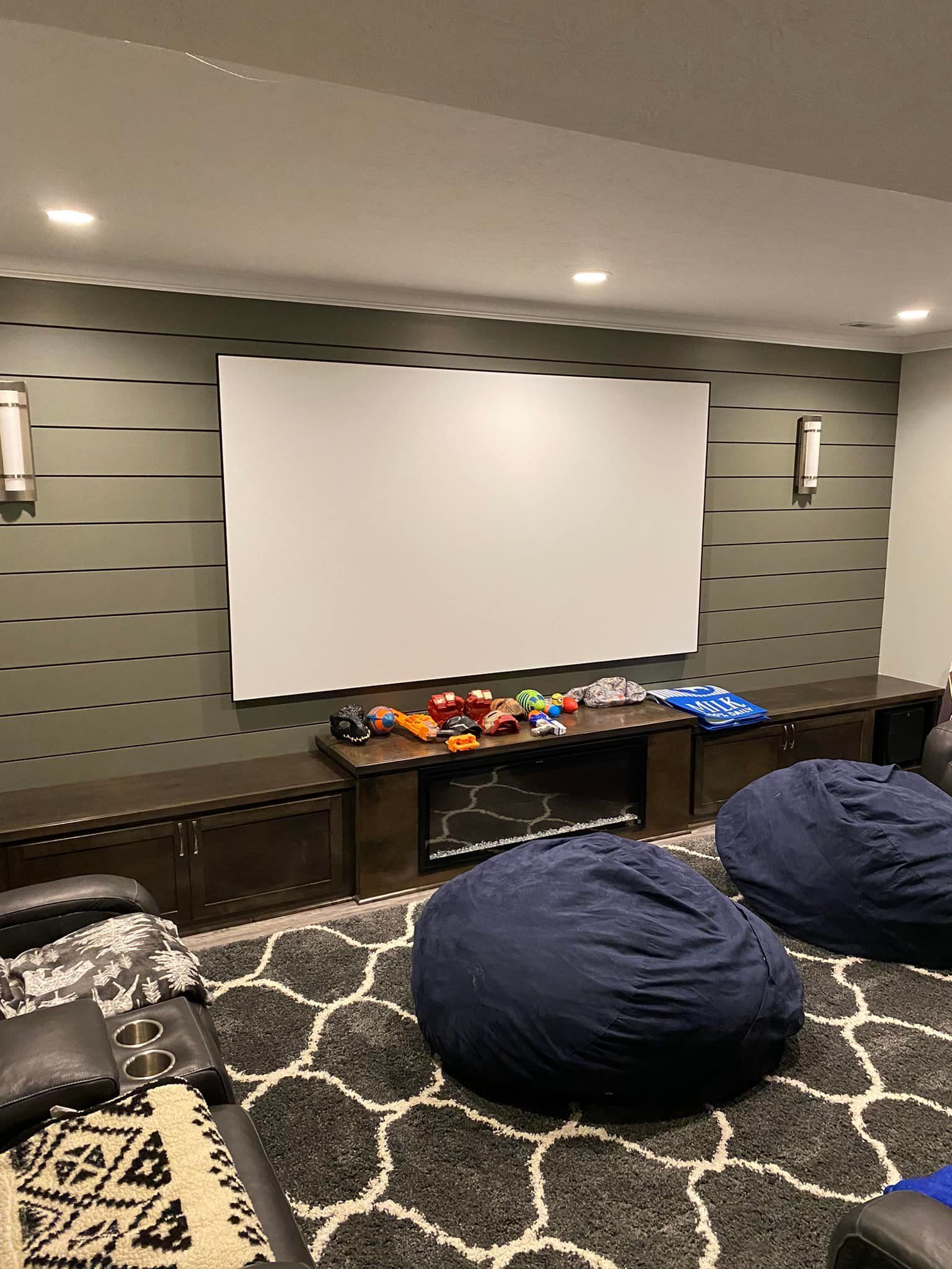 A home theater with bean bag chairs and a large screen.