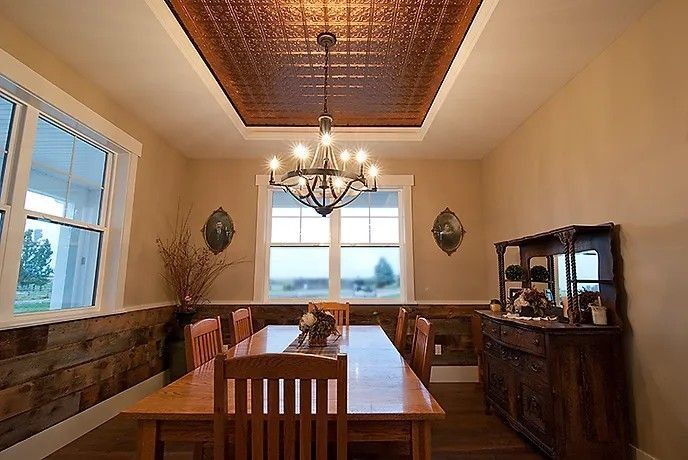 Dining room with wood table, chairs, and decorative copper ceiling.