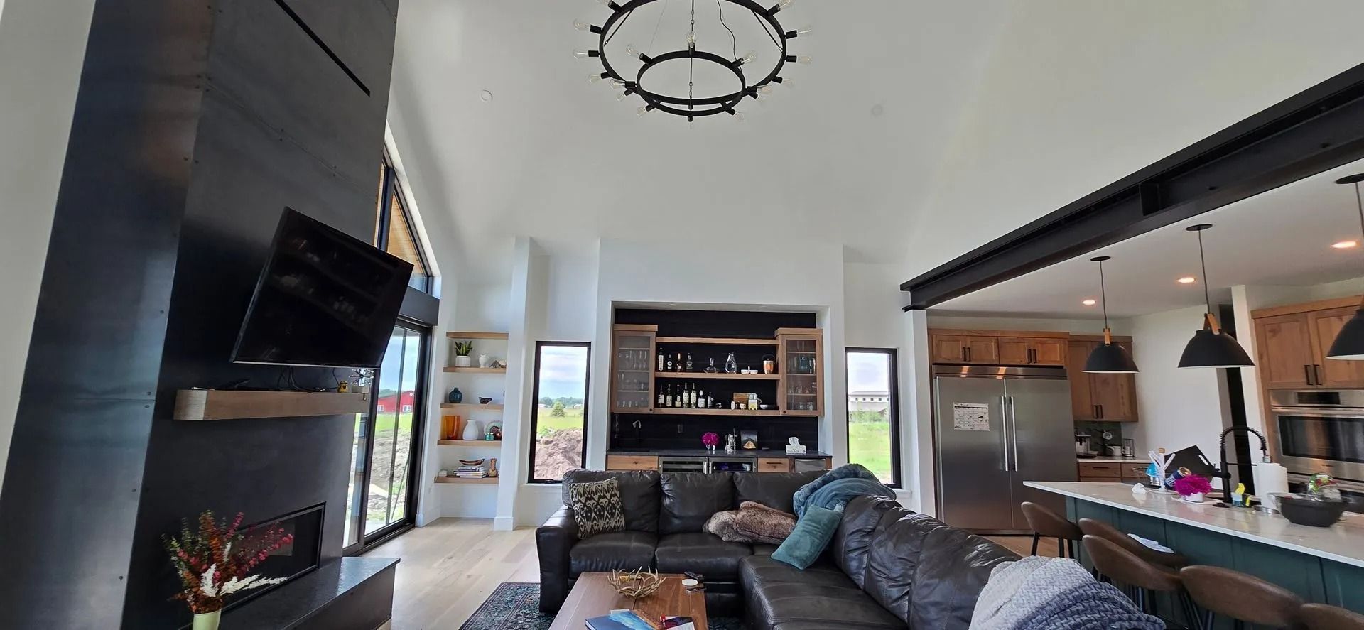 Living room with dark gray fireplace, sectional sofa, and kitchen with island.