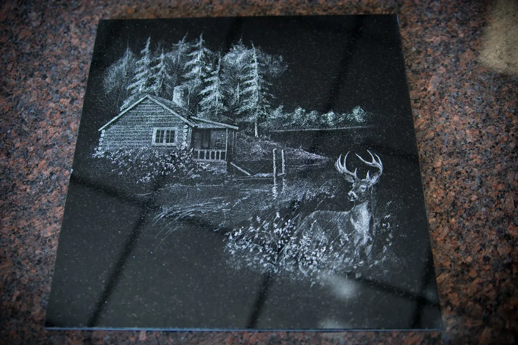 Chalk drawing of a deer in a snowy forest beside a cabin at night