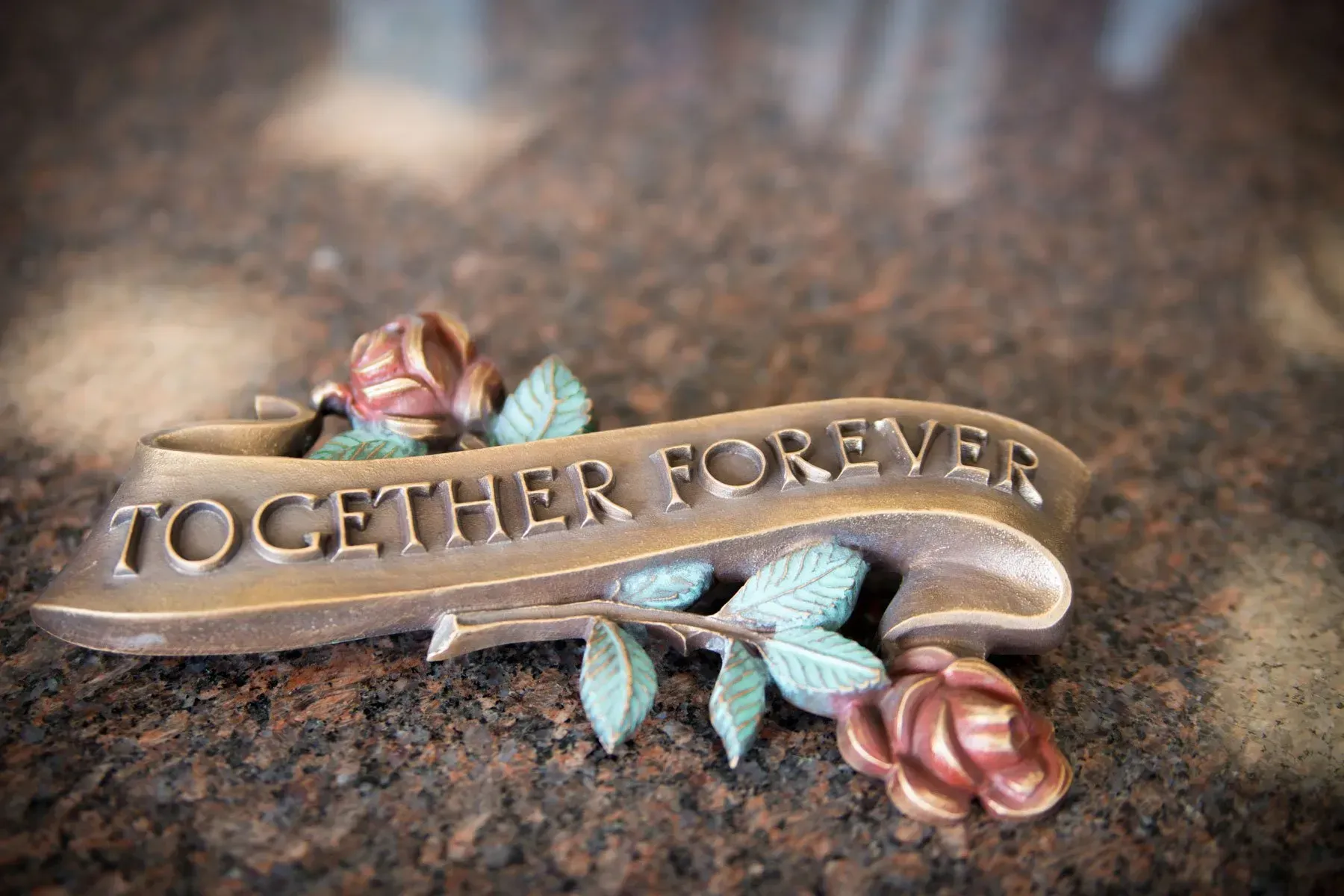Decorative plaque with roses and leaves reading “TOGETHER FOREVER” on a textured surface
