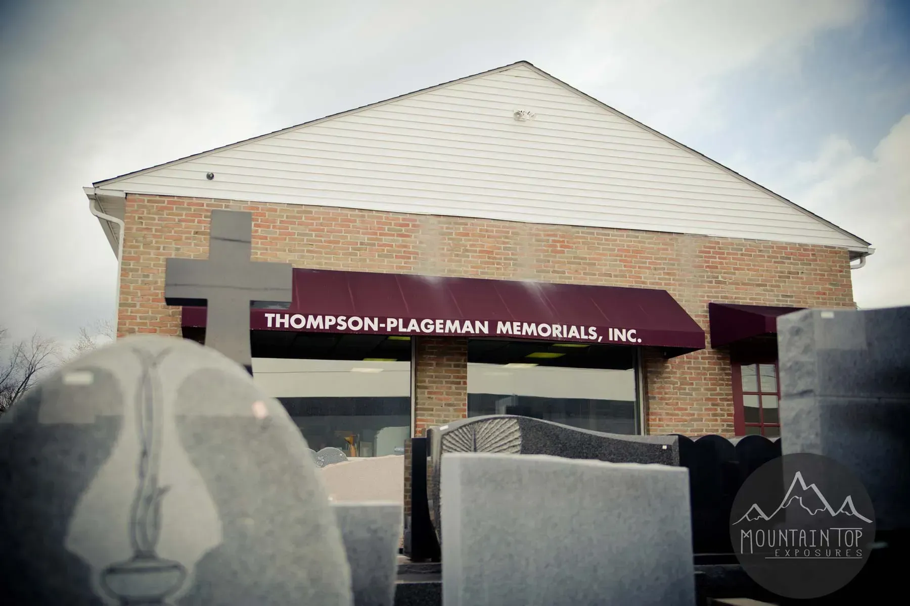 Thompson-Palmer Memorial Ltd. building with stone sign in the foreground on a cloudy day