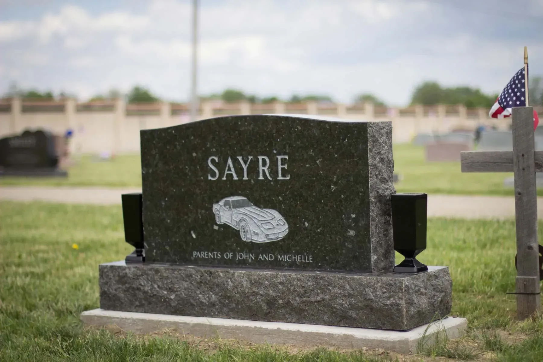 Sayre gravestone in a cemetery with an American flag nearby